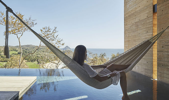 woman laying in hammock at balcony